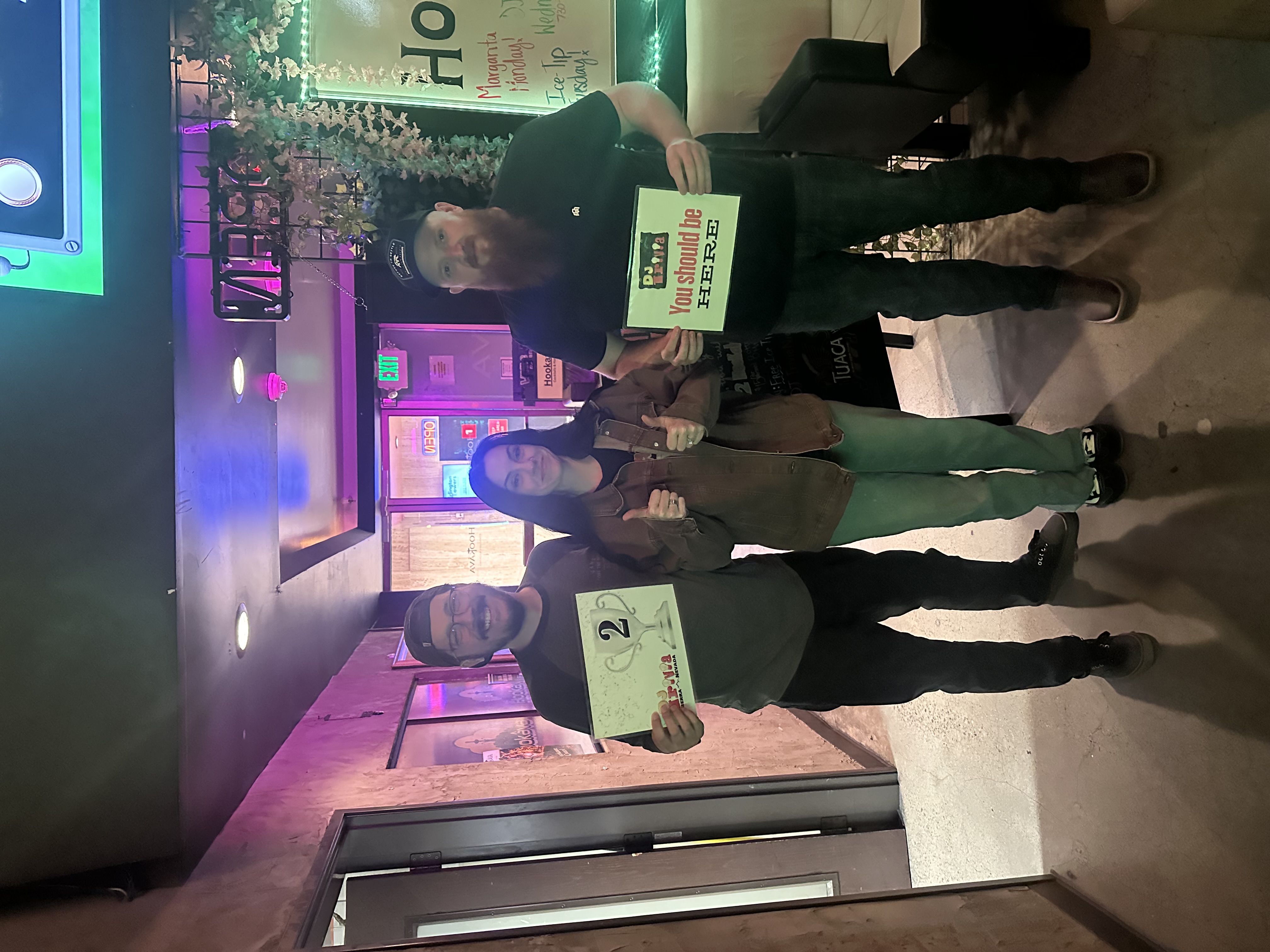 DJ Trivia 2nd place winners holding their prize card at Hookava